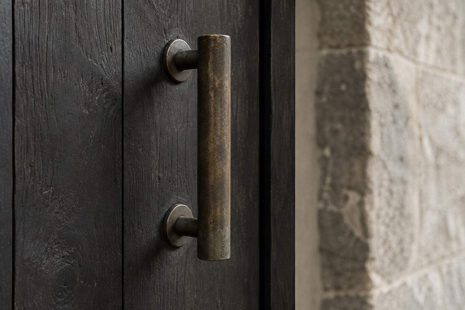 A bronze handle catching light against a dark surface.