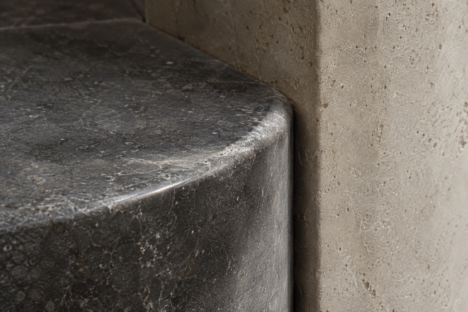 Soft light falling across pale stone and its rounded edge.